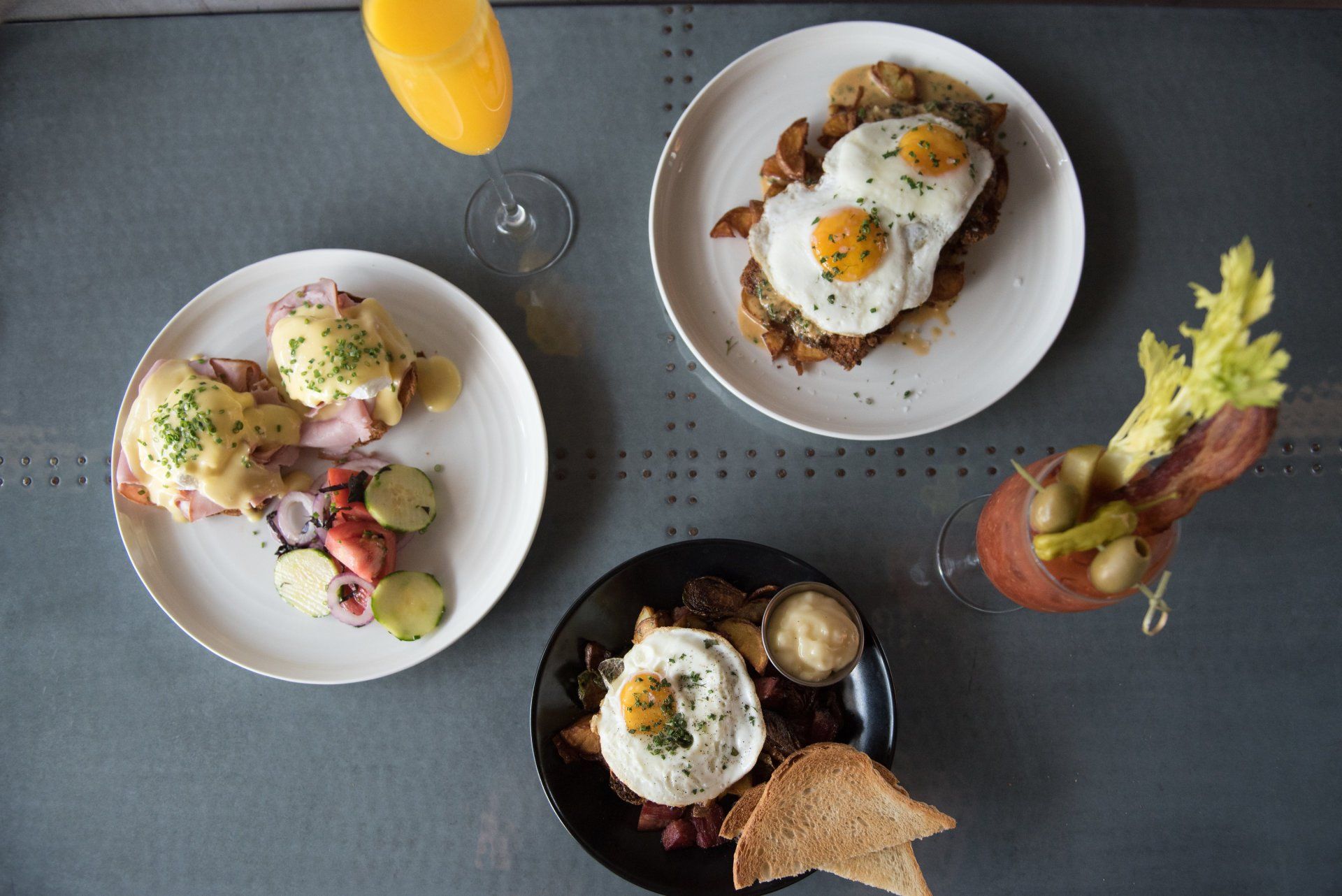 Three plates of food and a beverage on a table