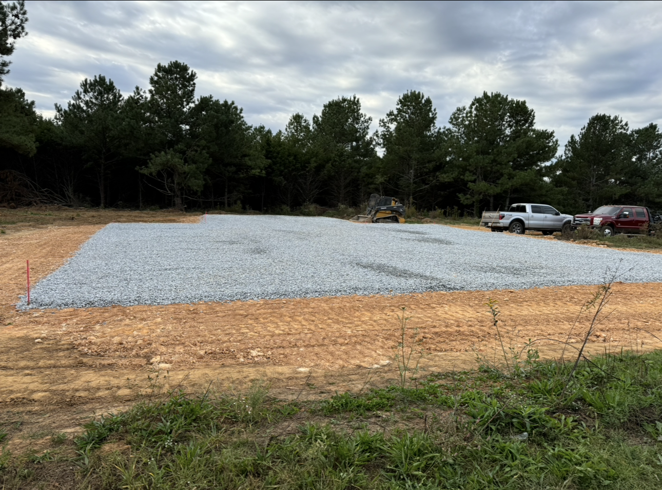 A large pile of gravel is sitting on top of a dirt field.