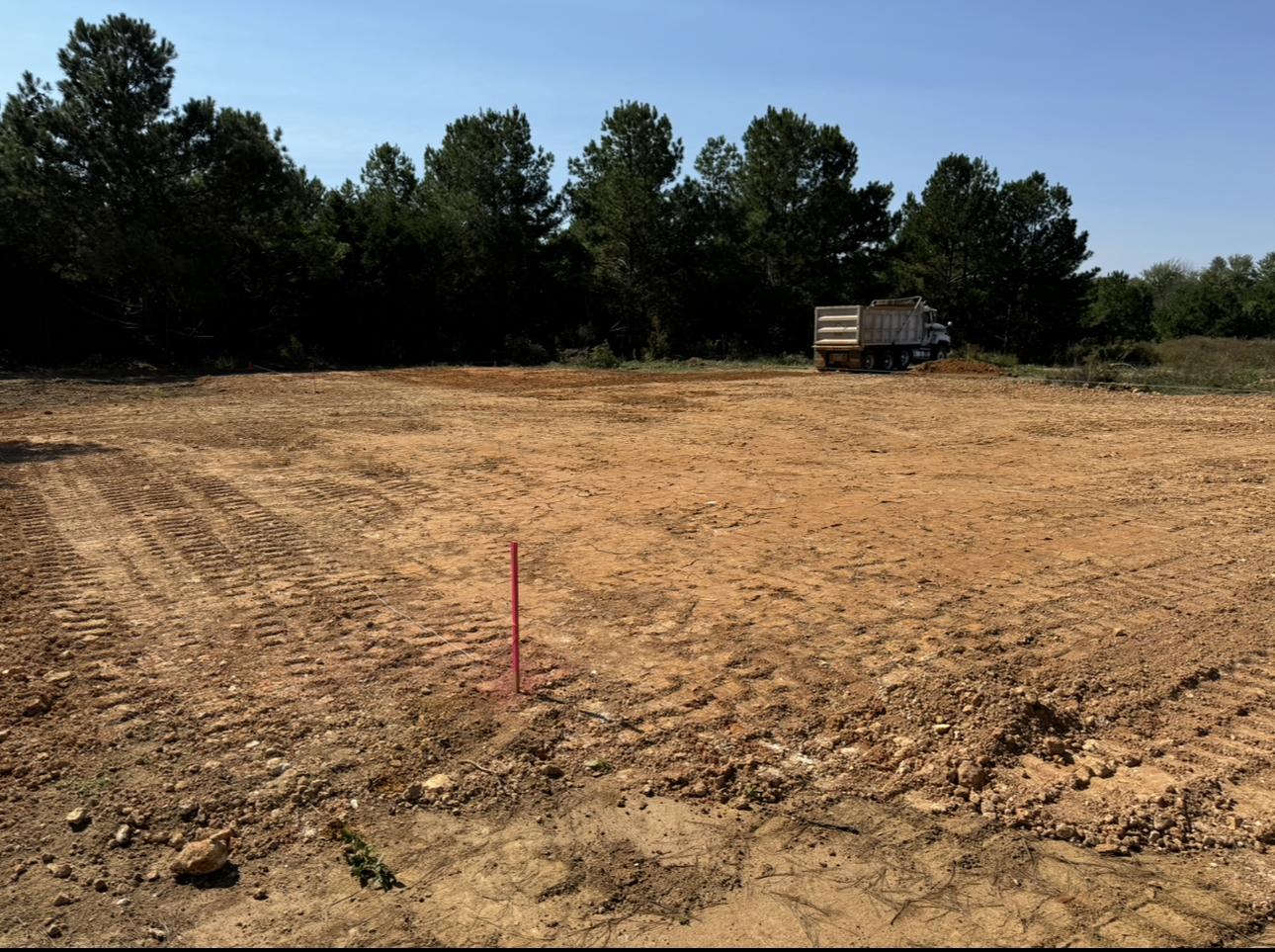 A truck is parked in the middle of a dirt field