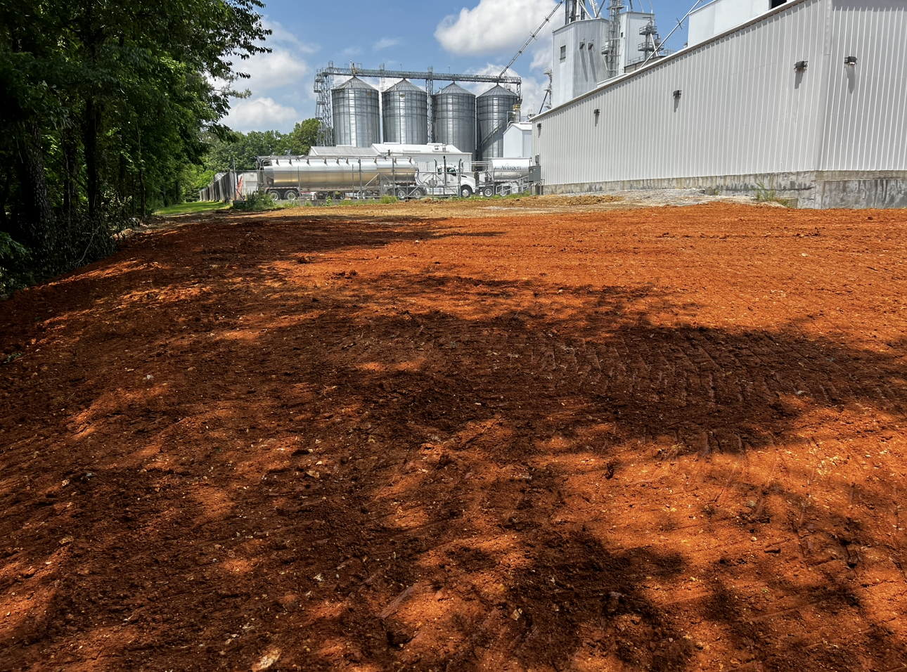 A large pile of dirt is sitting in front of a large building.