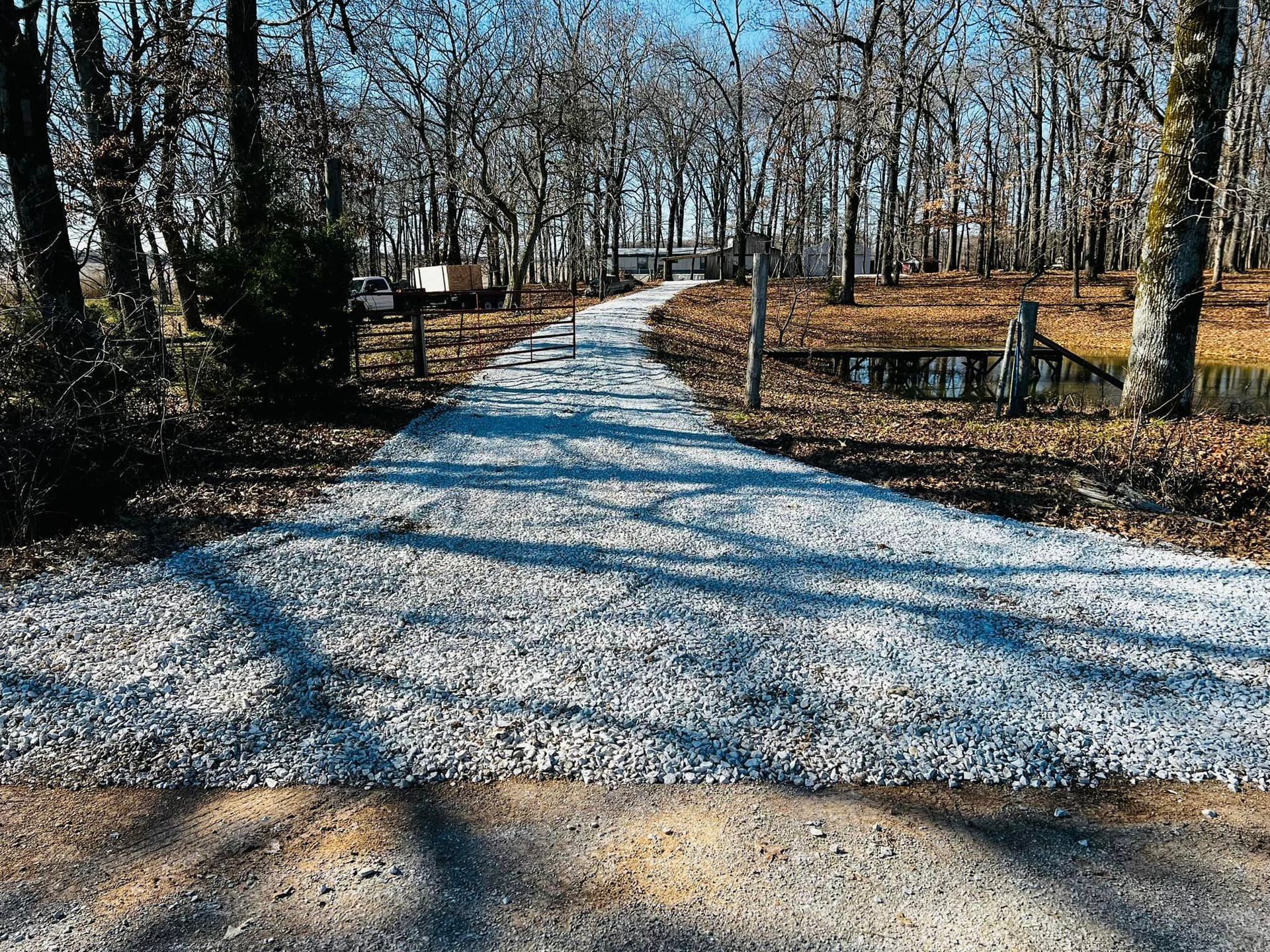 A gravel road going through a forest with trees on both sides