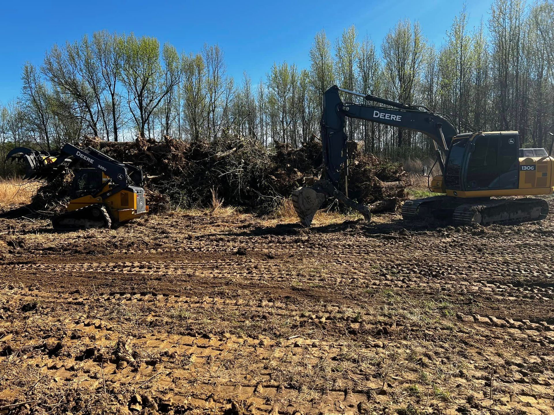 A large excavator is sitting in the middle of a dirt field.