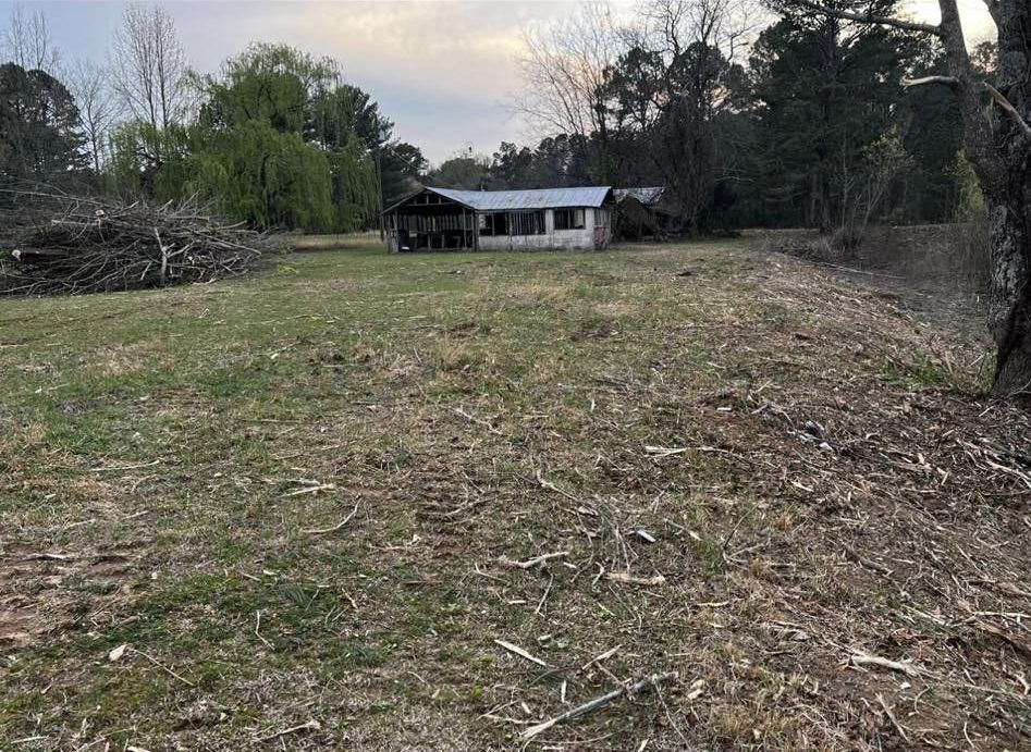 A house is sitting in the middle of a grassy field.
