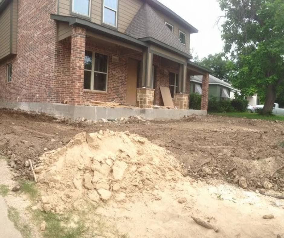 A brick house with a large pile of dirt in front of it