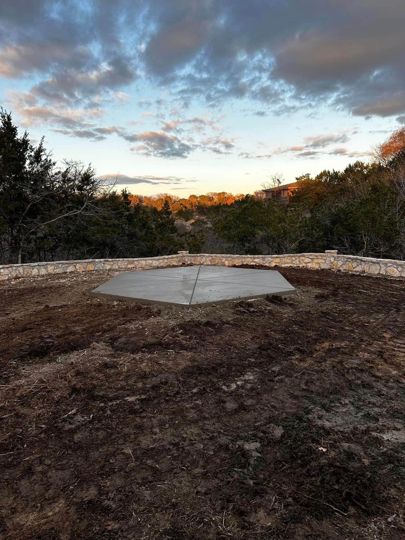 A large concrete slab is sitting in the middle of a dirt field.