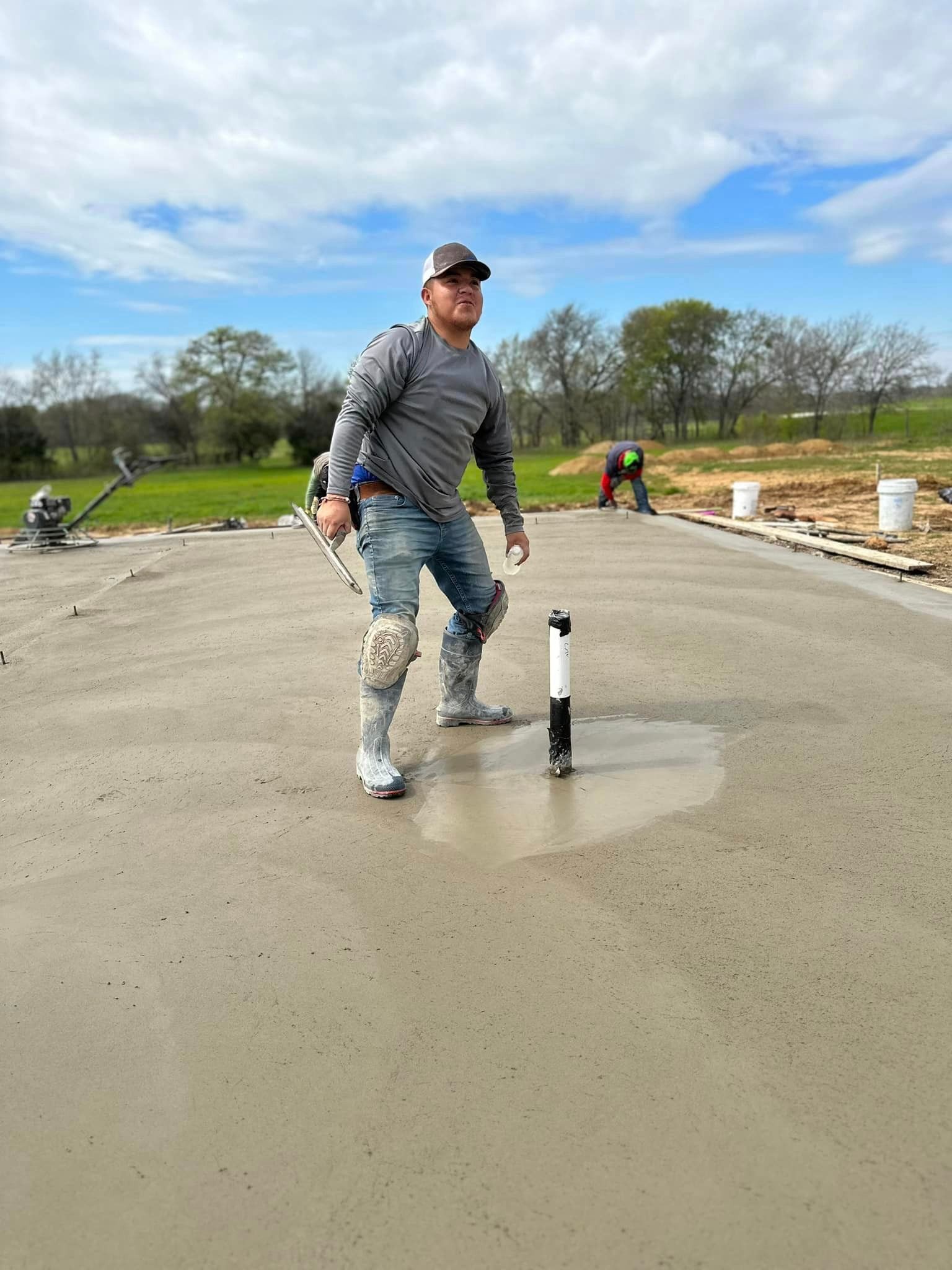 A construction worker is standing on a concrete floor.