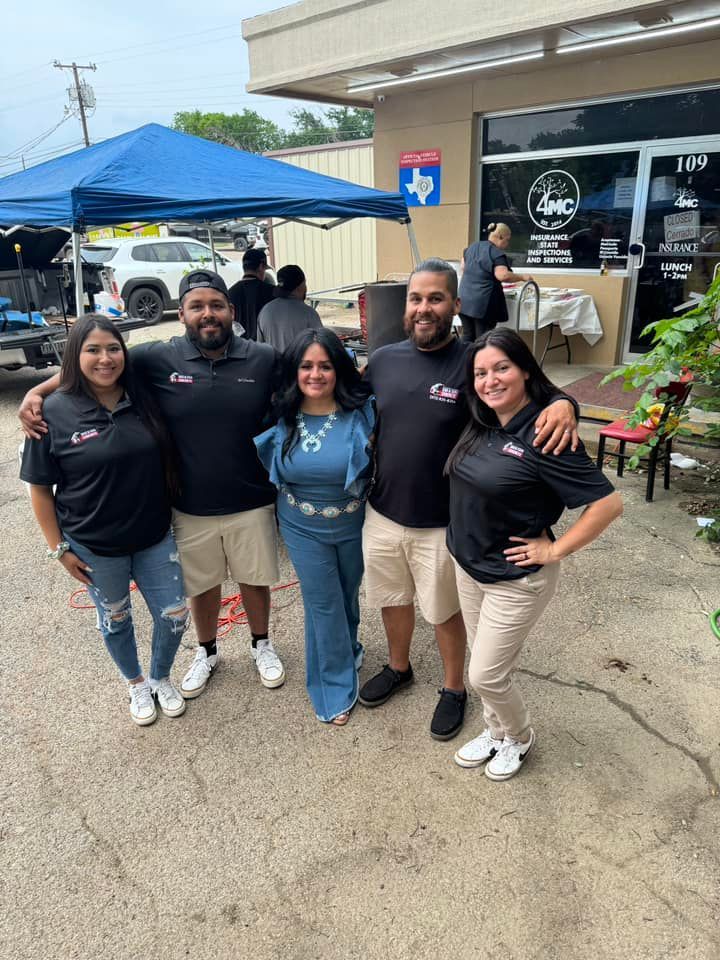 A group of people are posing for a picture in front of a building.