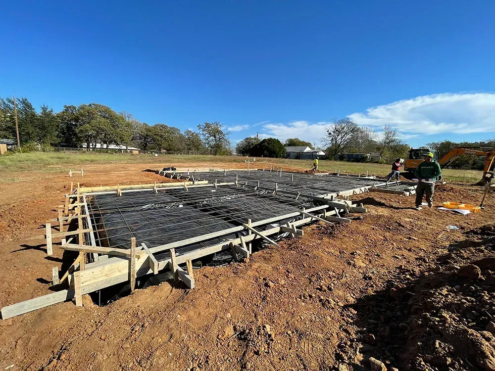 A man is standing in the middle of a dirt field.