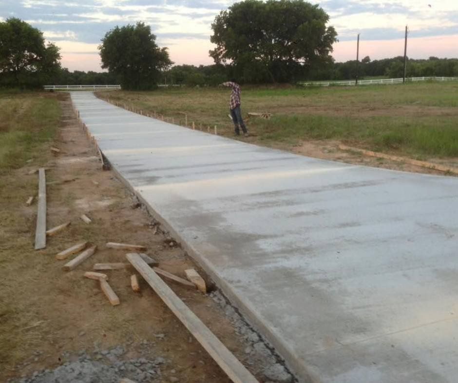 A man is standing on the side of a concrete road