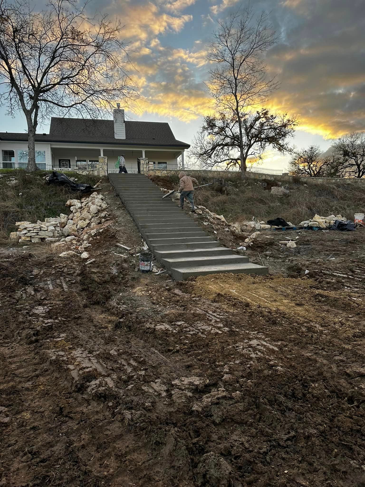 A house is being built on a hill with stairs leading up to it.