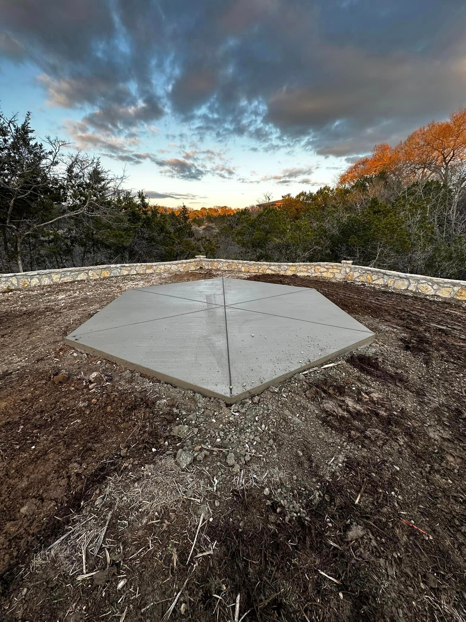 A large piece of concrete is sitting on top of a pile of dirt.