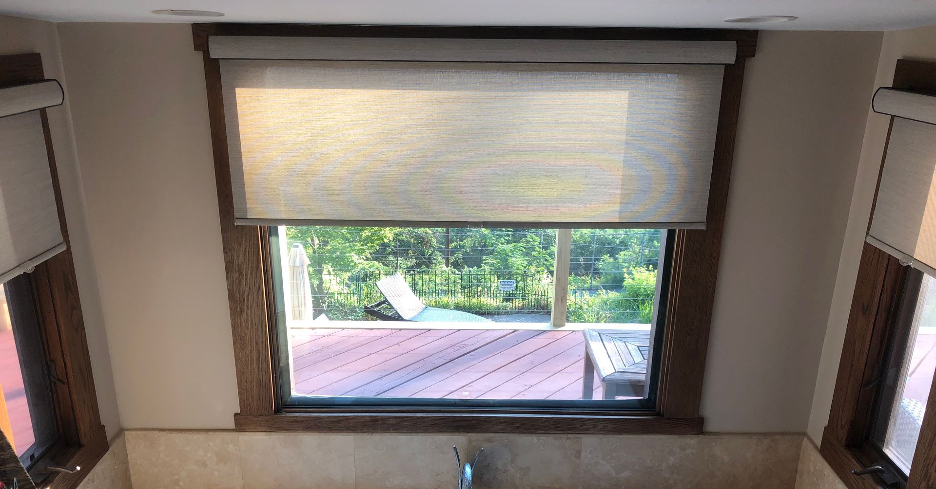 A bathroom with a sink and a window with blinds on it.