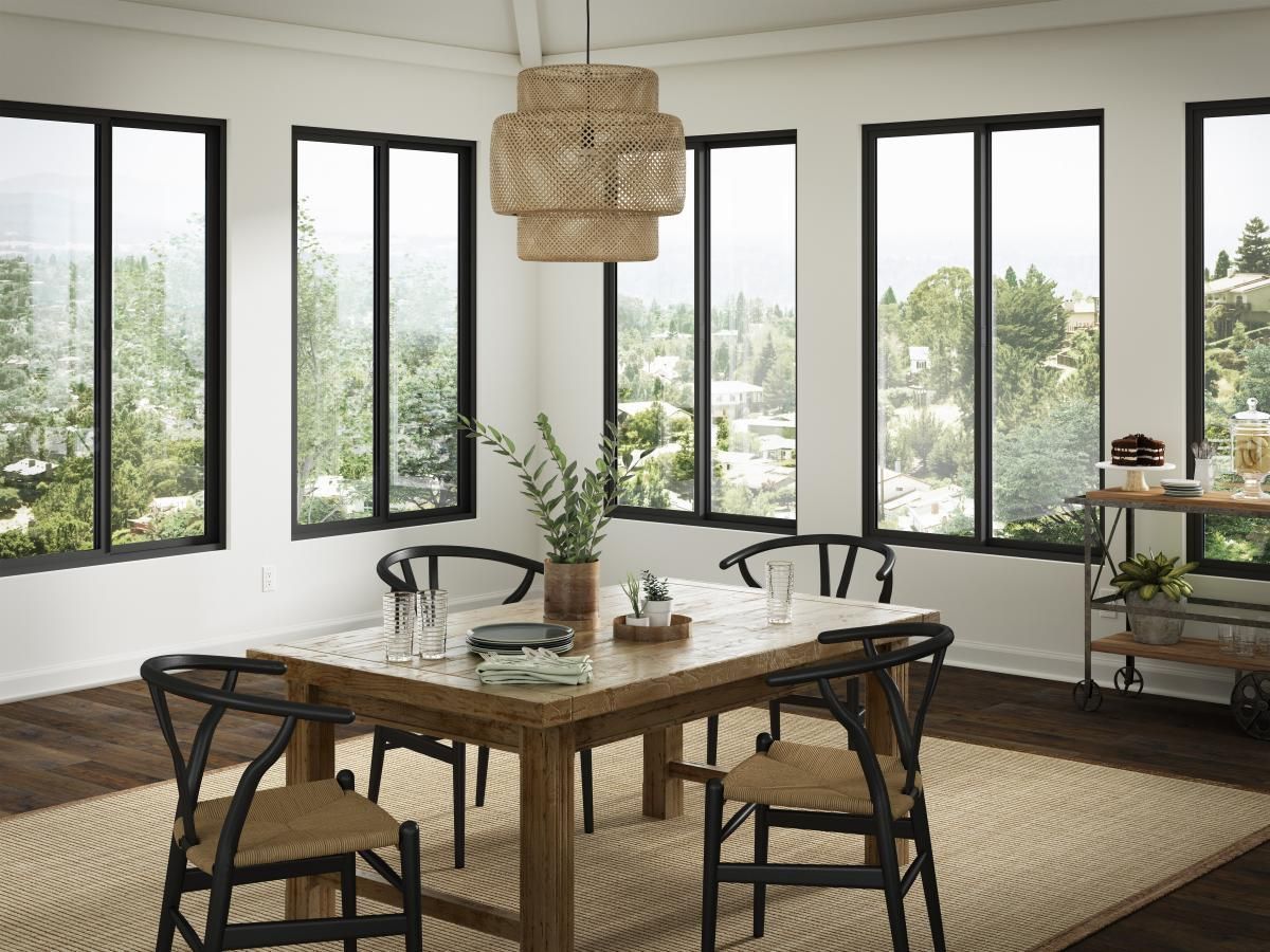 Modern dining room with black-framed windows, wood table, wicker chairs, and woven pendant light