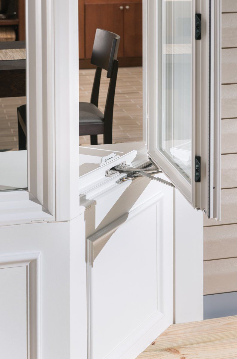 Damaged white glass door with broken hinge and shattered panel on a porch