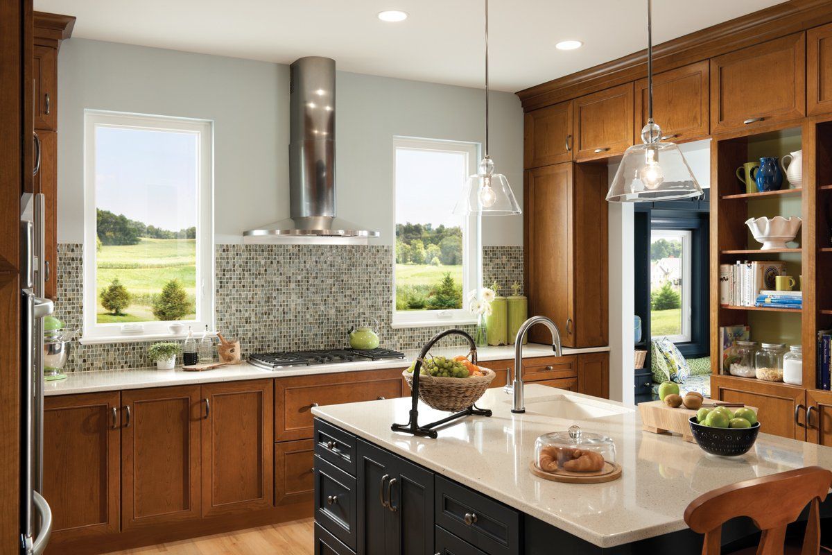Bright kitchen with wood cabinets, island, window views, and stainless-steel appliances