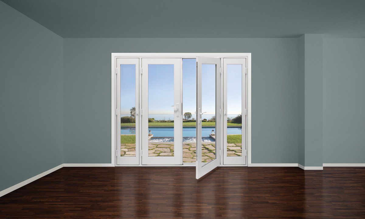 Empty room with gray walls, dark wood floor, and large glass doors opening to a waterfront view.
