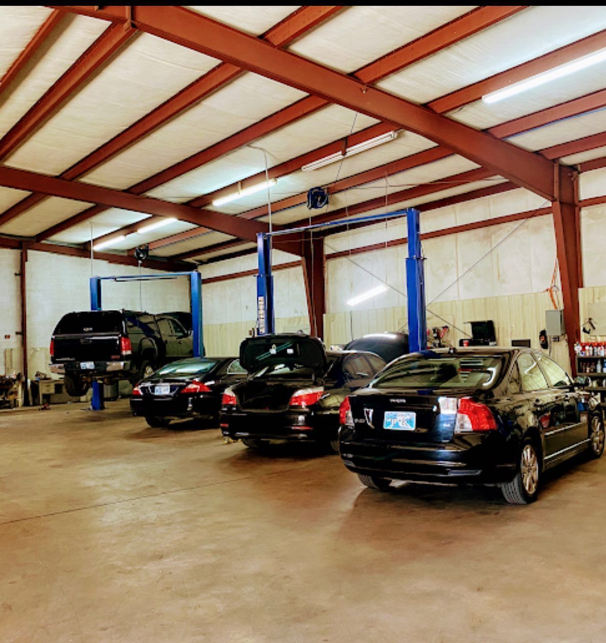 A row of cars are parked inside of a garage