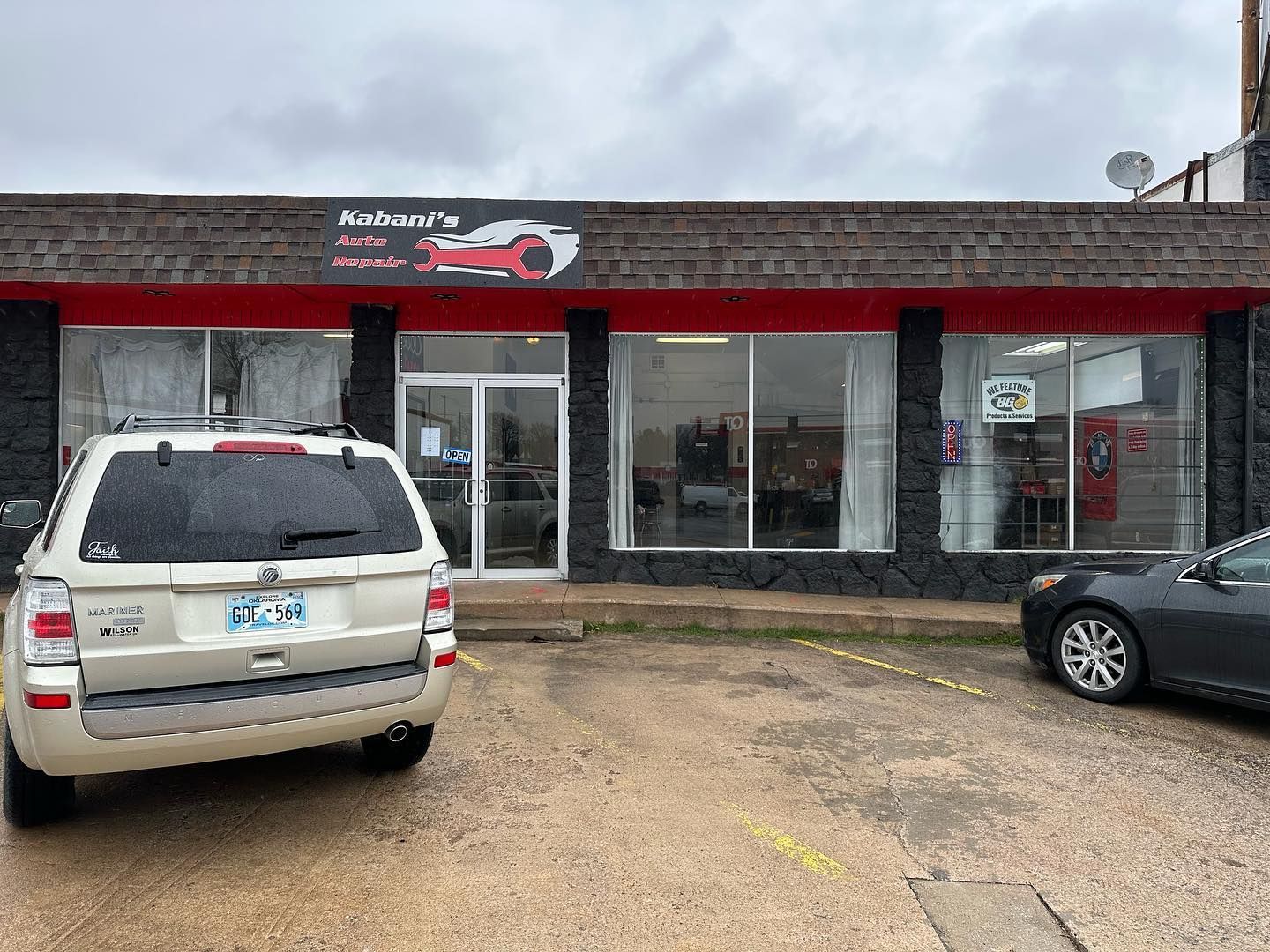 A car is parked in front of a car dealership.
