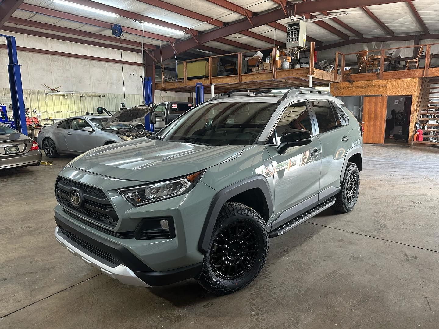 A gray toyota rav4 is parked in a garage.