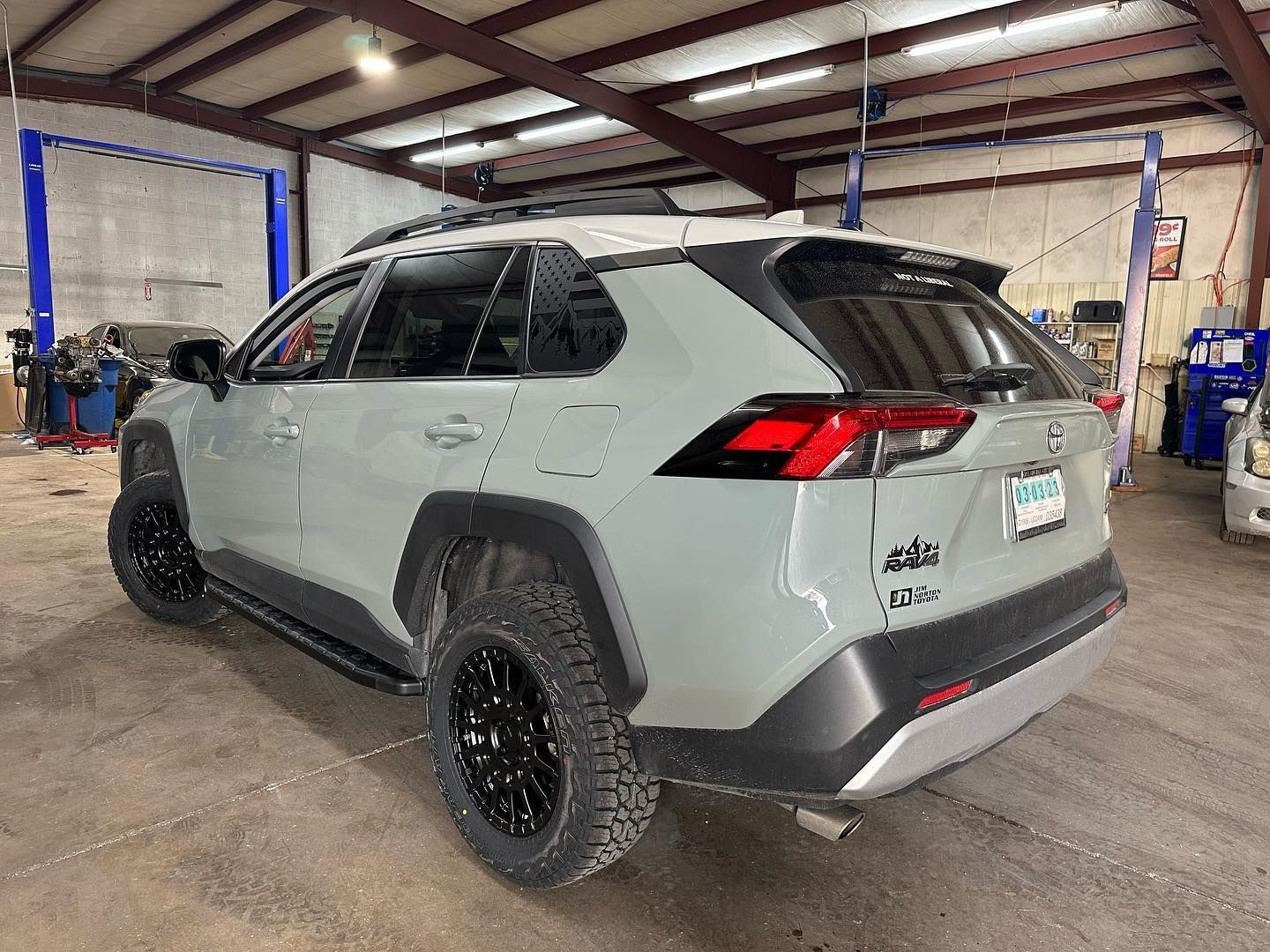 A gray toyota rav4 is parked in a garage.