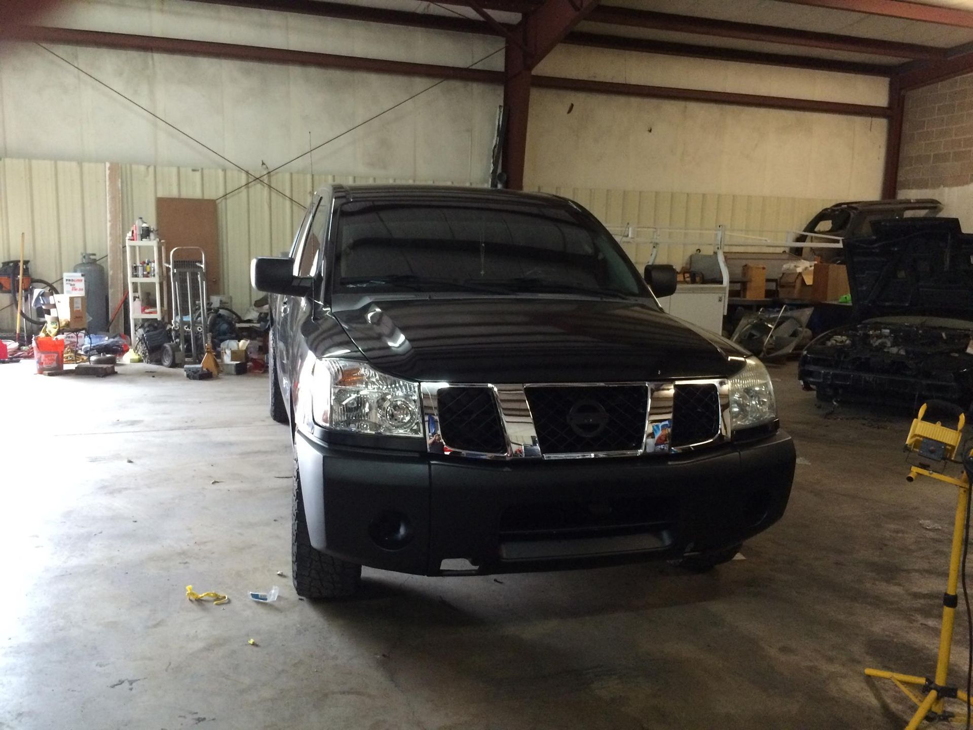 A black nissan titan is parked in a garage