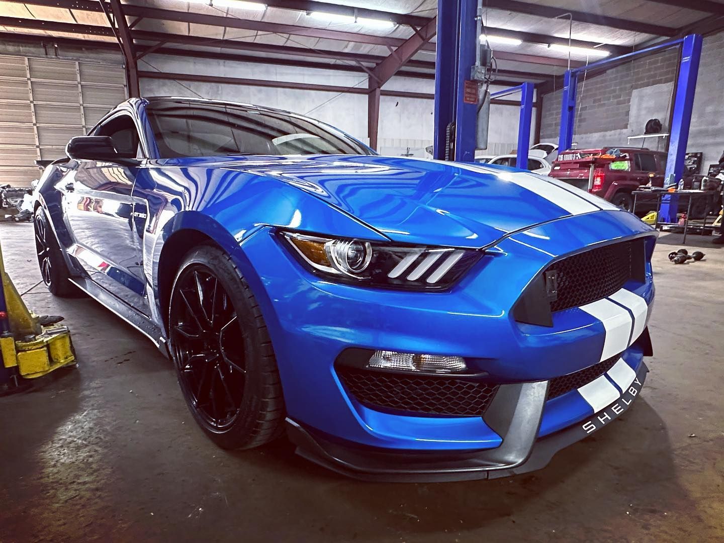 A blue ford mustang is parked in a garage.