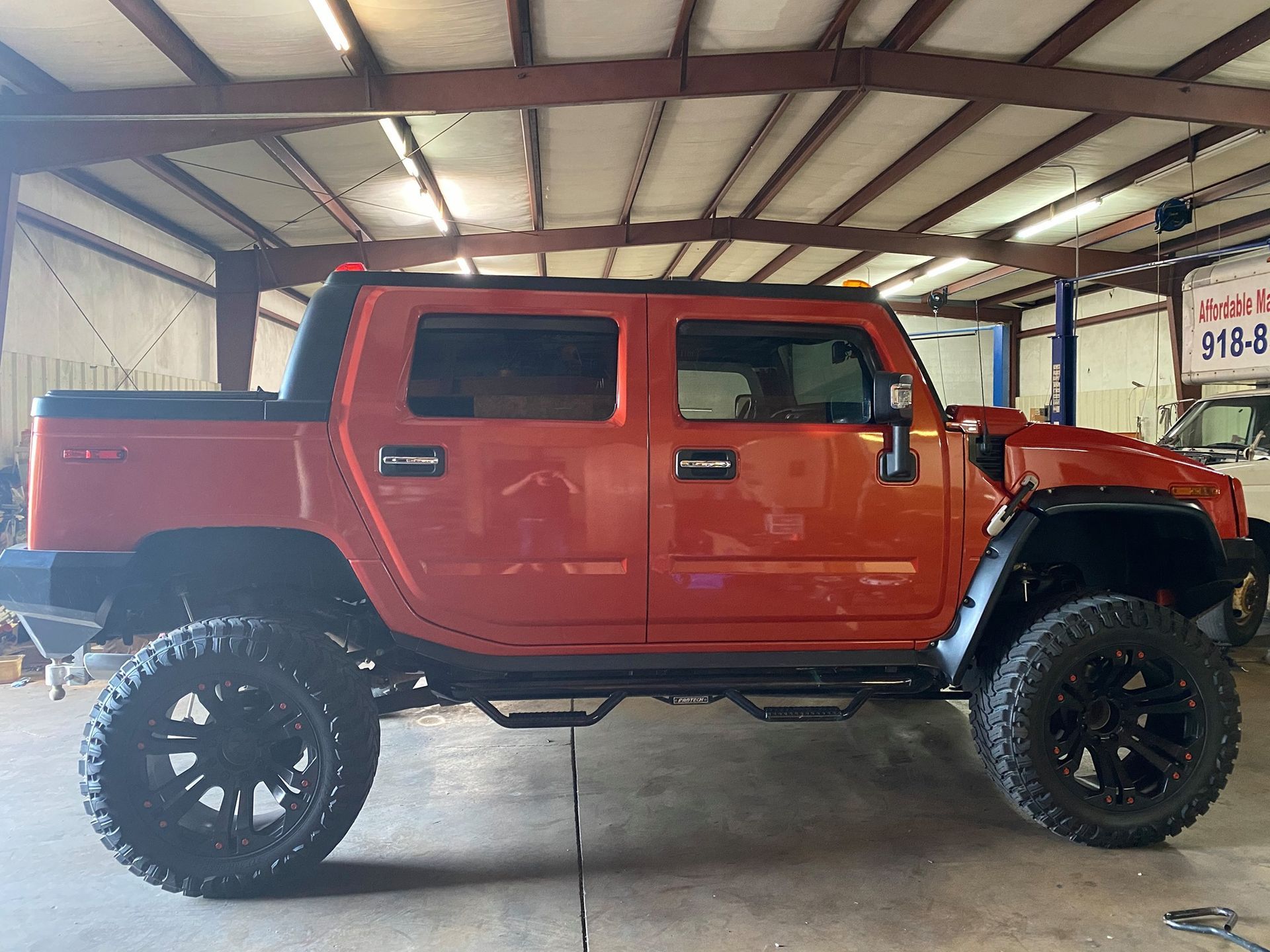 A red hummer truck is parked in a garage.