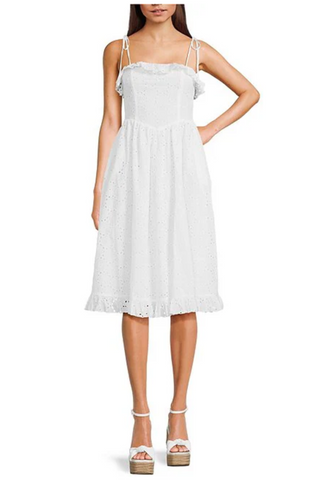 A woman is wearing a white dress and white shoes.