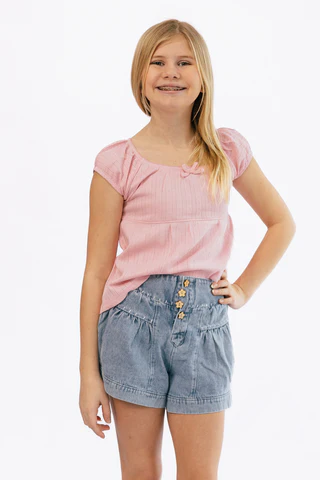 A woman is wearing a pink t-shirt and blue jeans