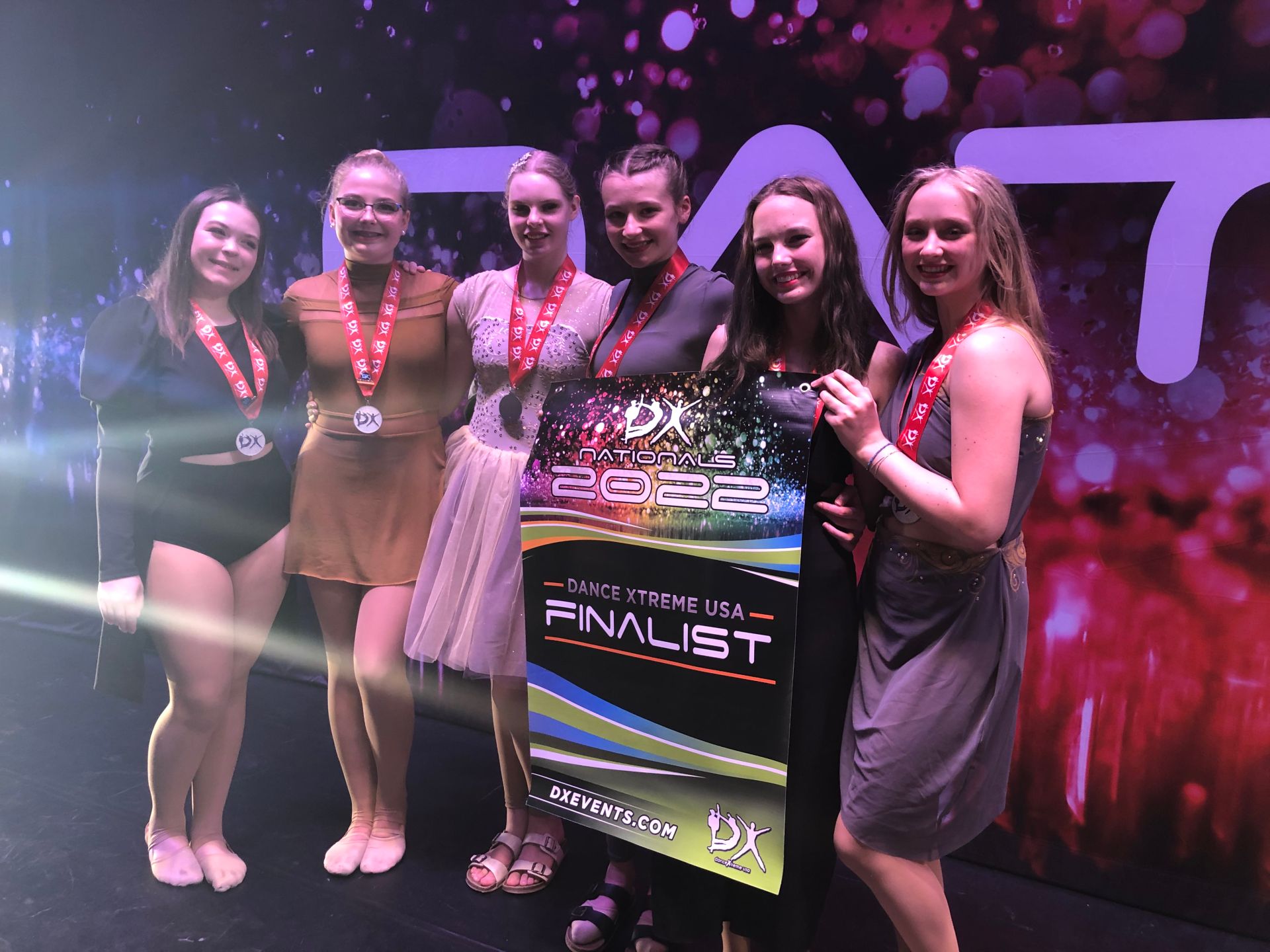 A group of young women are standing next to each other holding a trophy