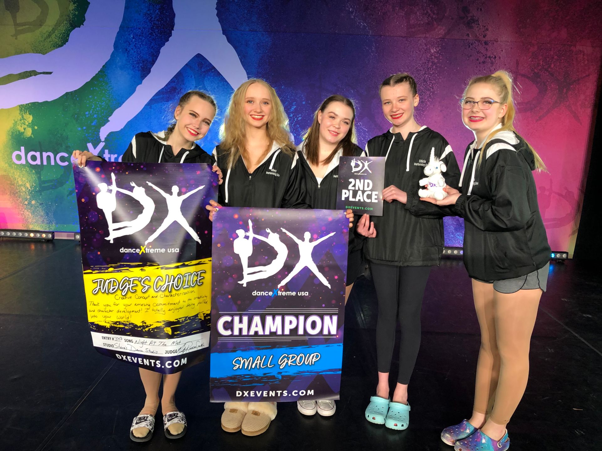 A group of young girls are holding a sign that says DX Champion