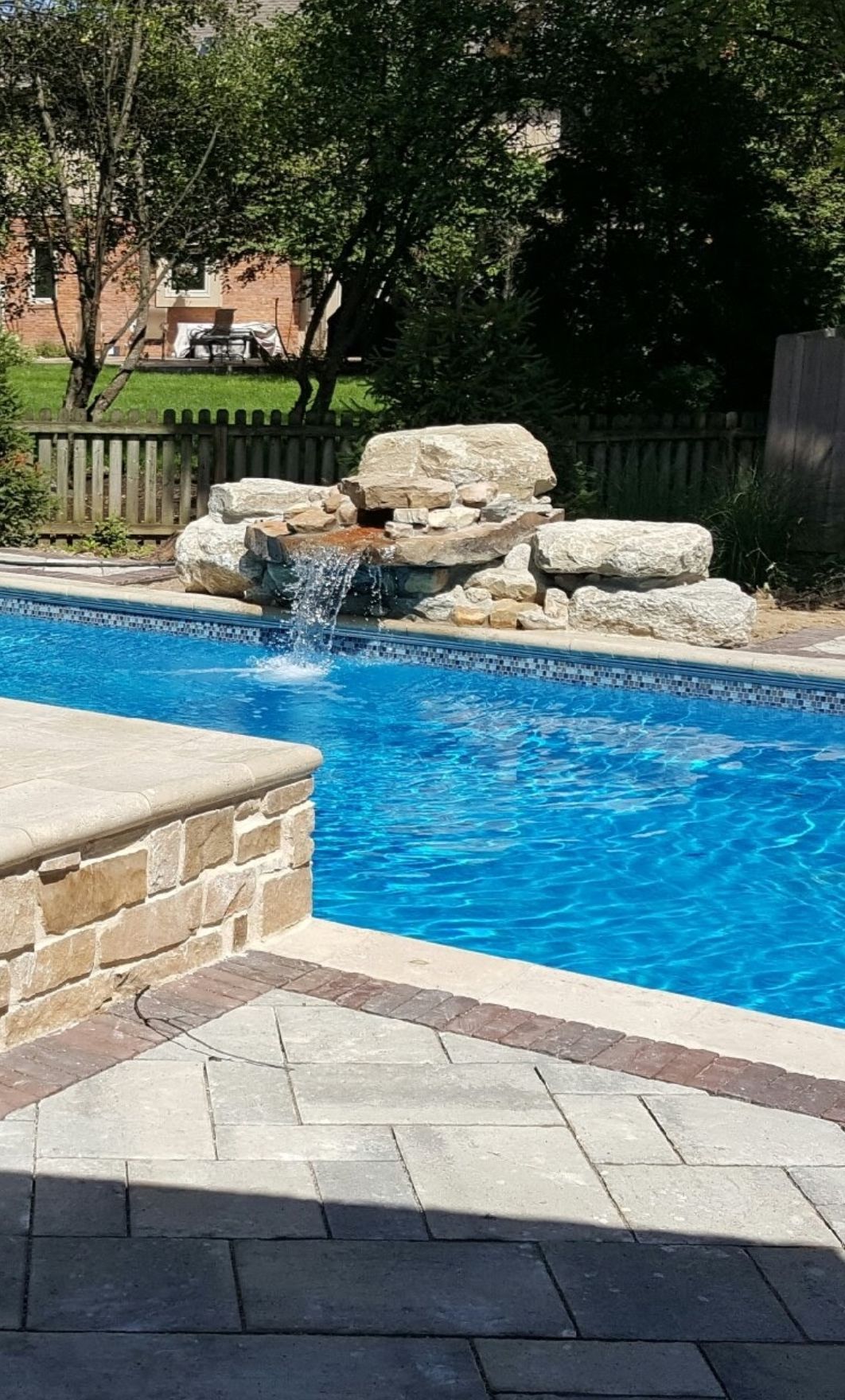 There is a waterfall in the middle of the pool.