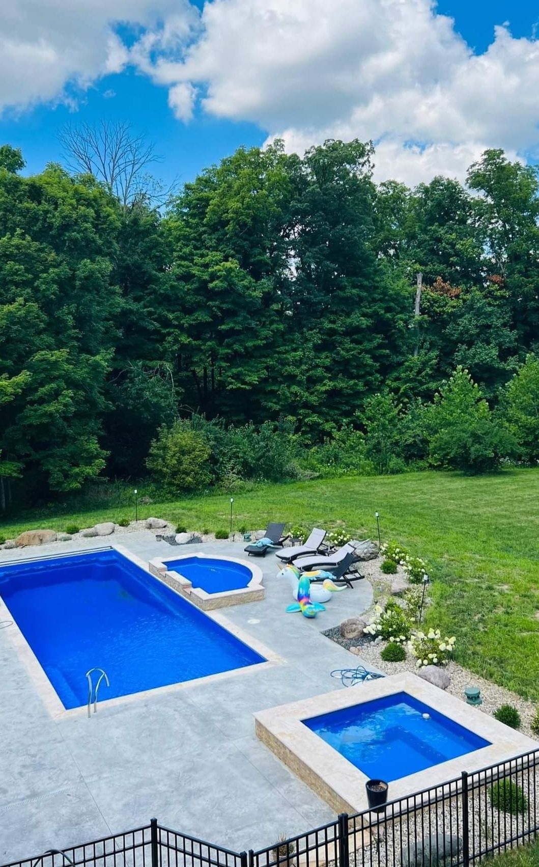 There are two swimming pools and a hot tub in the backyard.