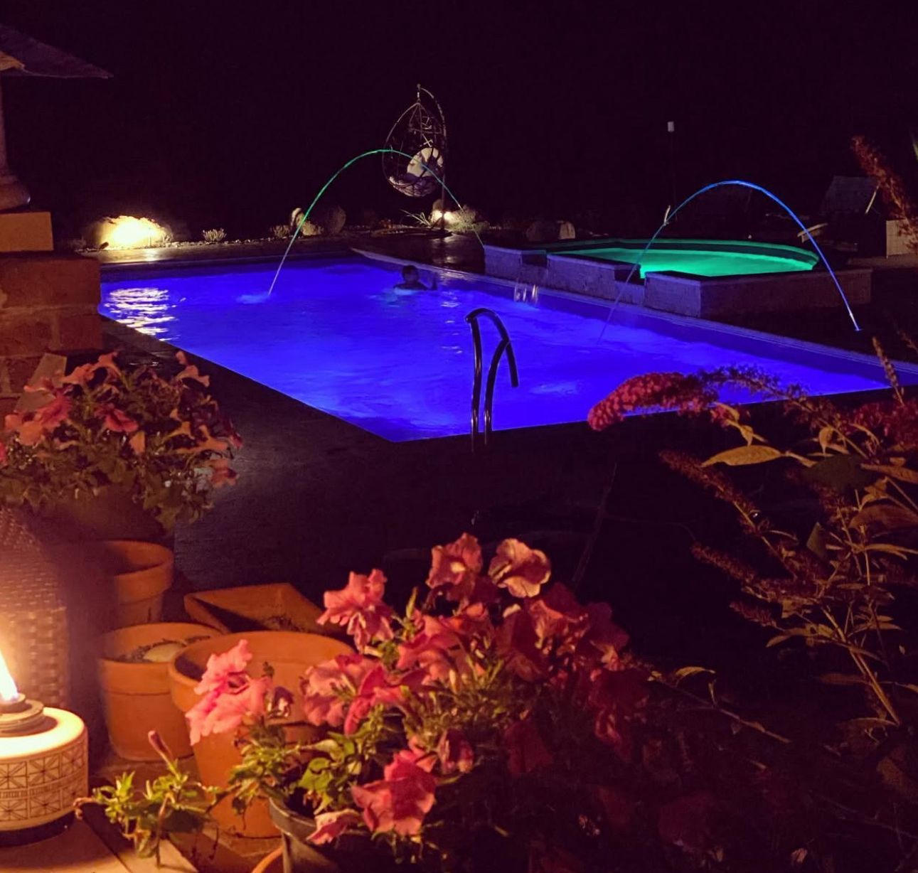 A large swimming pool is lit up at night