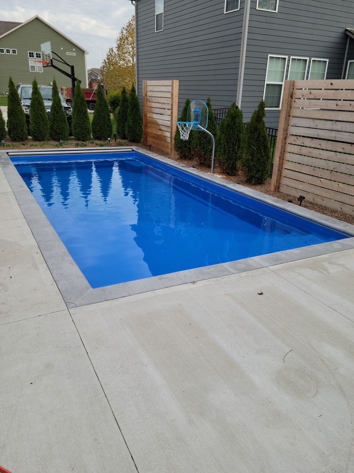 A large blue swimming pool in front of a house