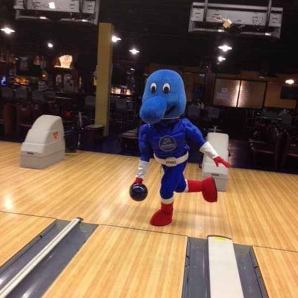 A blue mascot is bowling on a bowling alley