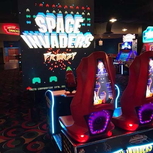 A video game called space invaders is being played in an arcade