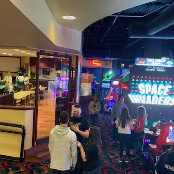 A group of people standing in front of a sign that says space invaders