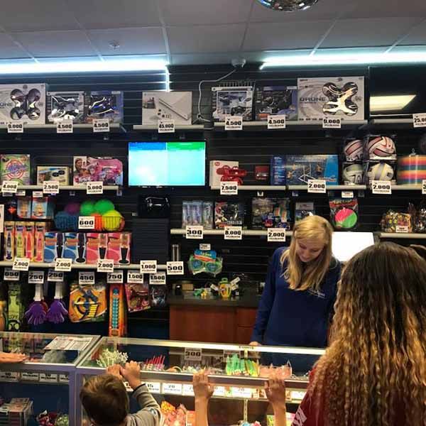 A group of people are standing in a store looking at toys.