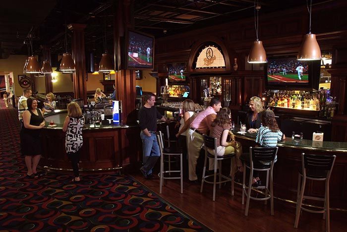A group of people are sitting at a bar in a restaurant
