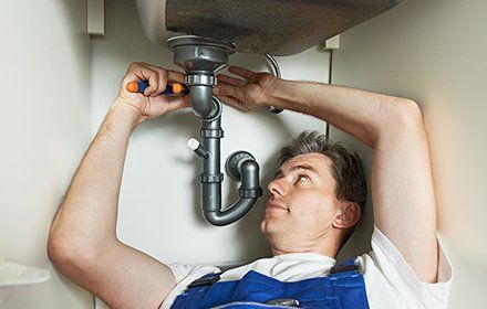 A Plumber Fixing the Sink