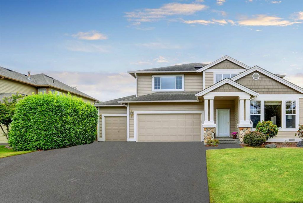 A large house with a large driveway in front of it.