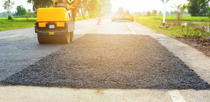A roller is rolling asphalt on a road.