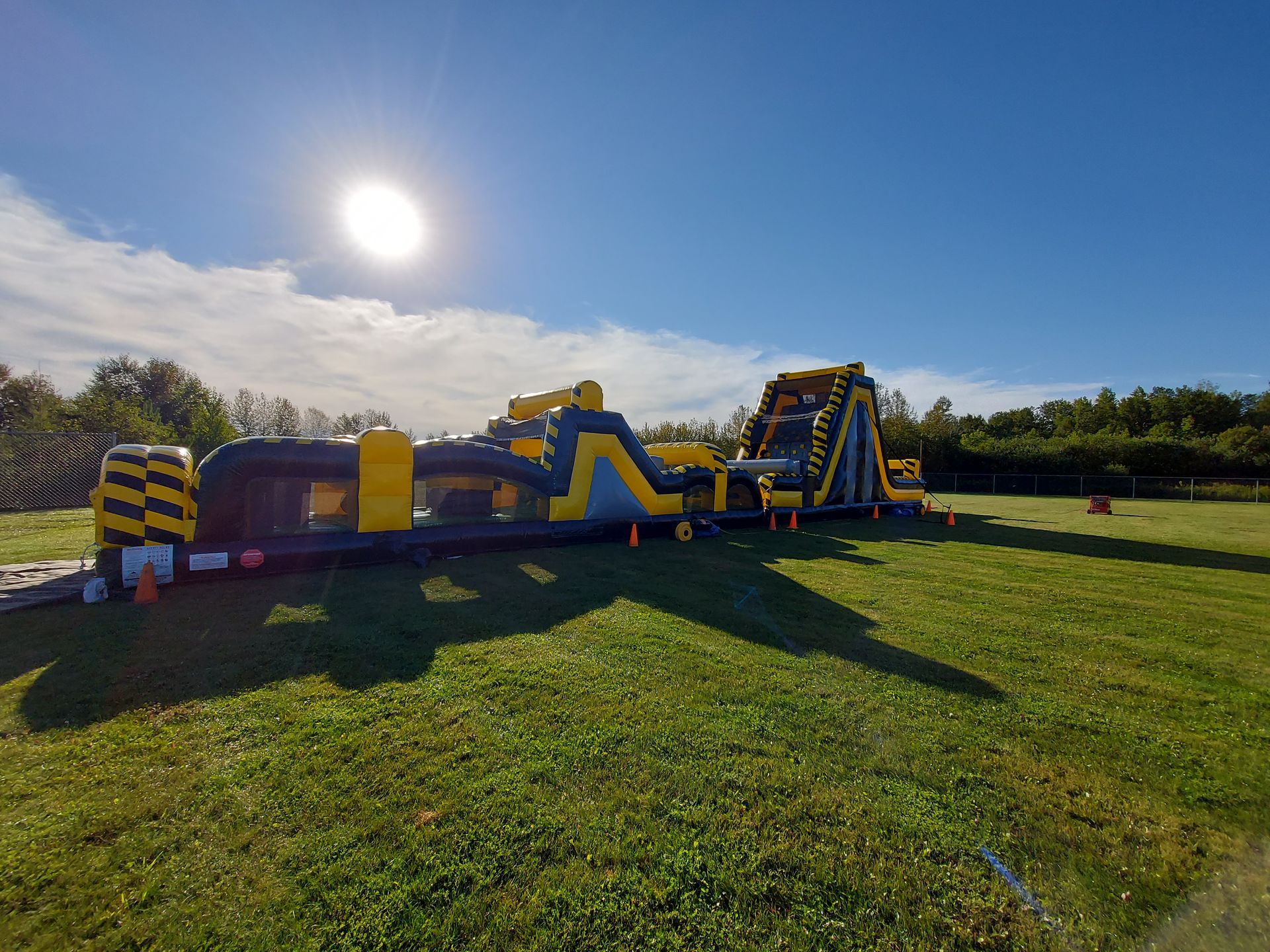 A large inflatable obstacle course is sitting in the middle of a grassy field.