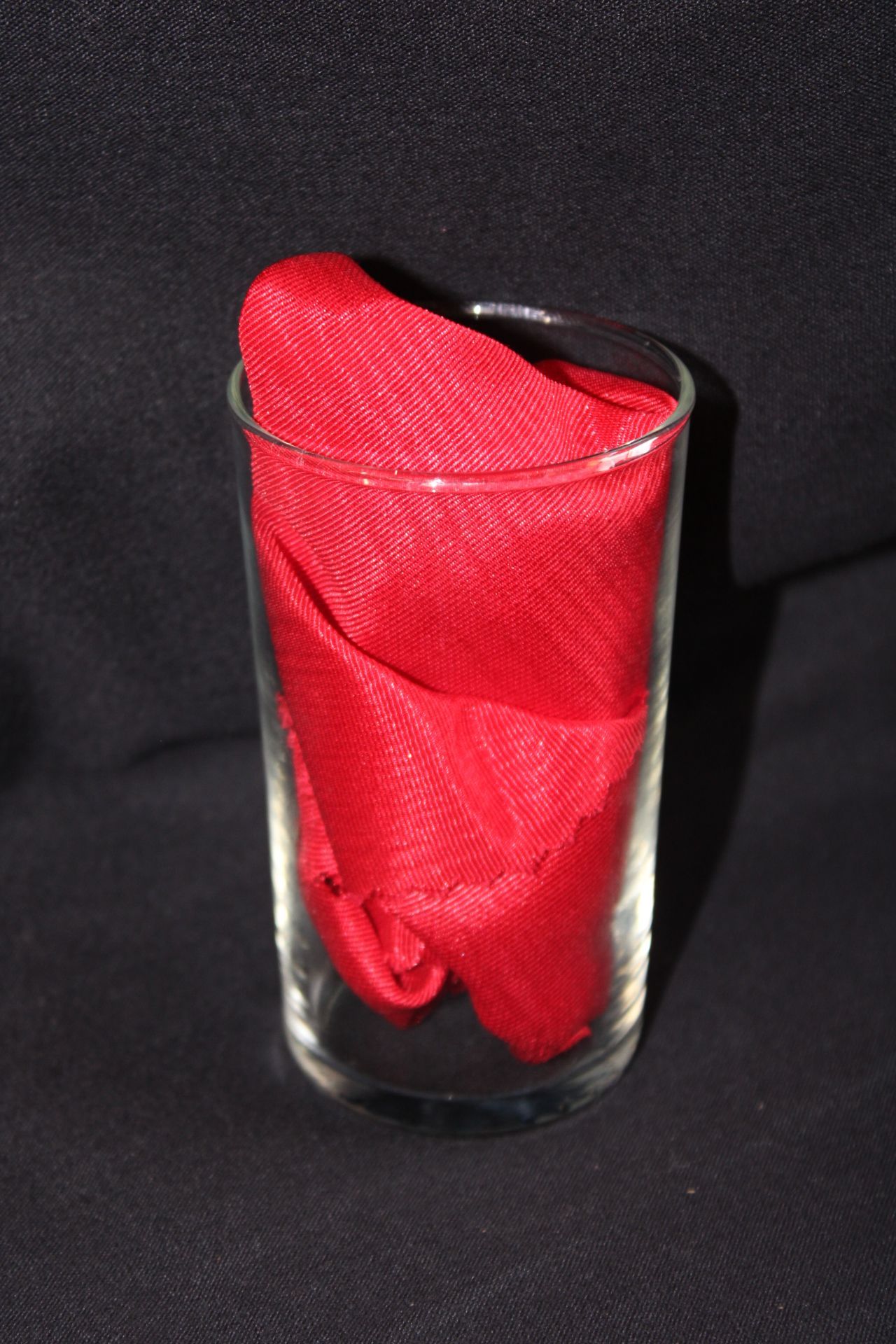 A glass with a red napkin in it