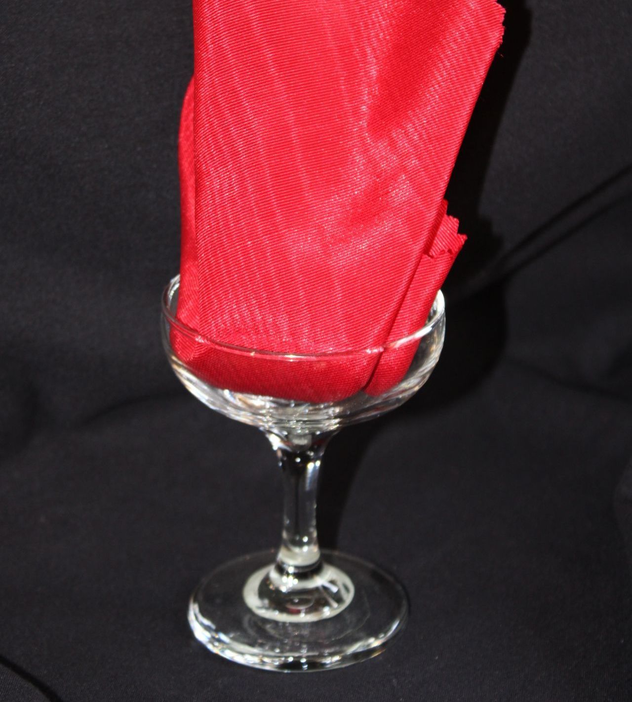 A wine glass with a red napkin in it