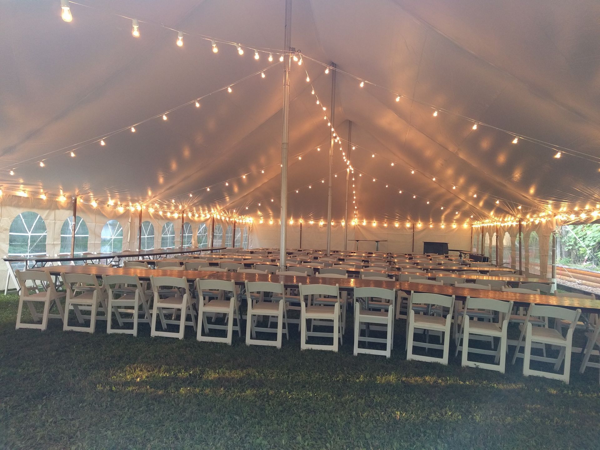 A large tent with tables and chairs underneath it