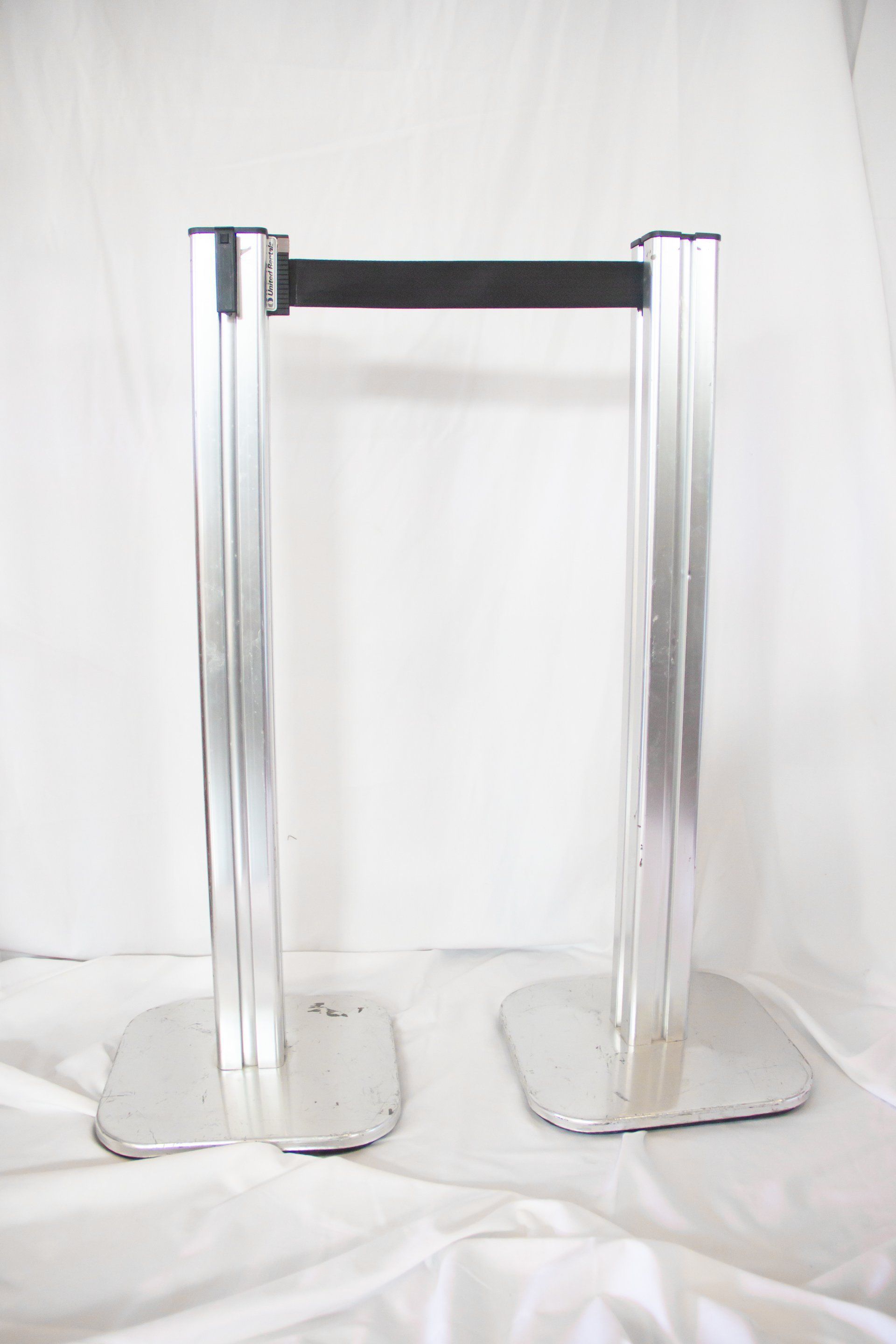 A pair of metal poles with a black belt attached to them