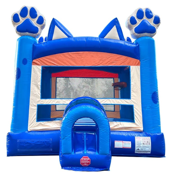 A red and blue bouncy castle is sitting in the grass.