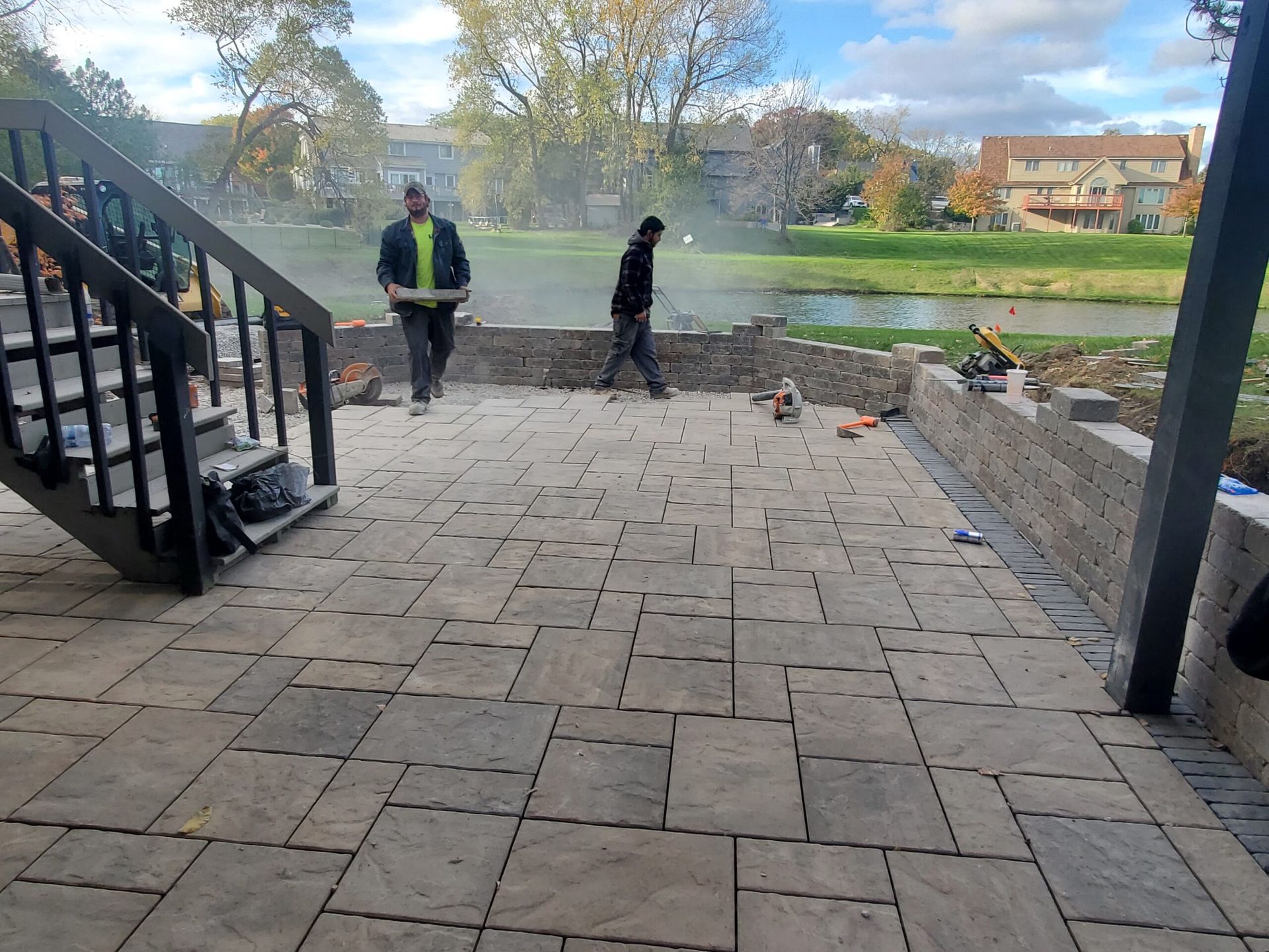 Circular brick patio under construction, with edging and grass border.